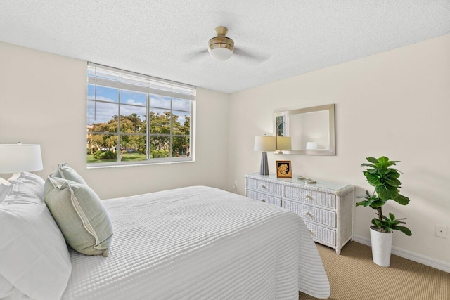 127 Yacht Club Way Unit 206, Hypoluxo, FL 33462 - bedroom featuring baseboards, a textured ceiling, ceiling fan, and light colored carpet