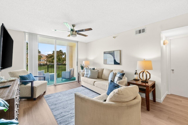 127 Yacht Club Way Unit 206, Hypoluxo, FL 33462 - living area with light wood finished floors, a textured ceiling, a ceiling fan, and visible vents
