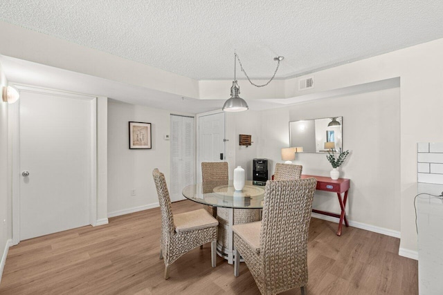 127 Yacht Club Way Unit 206, Hypoluxo, FL 33462 - dining space with light wood-type flooring, visible vents, baseboards, and a textured ceiling
