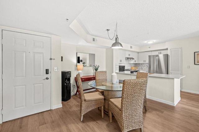 127 Yacht Club Way Unit 206, Hypoluxo, FL 33462 - dining space featuring baseboards, light wood-style floors, visible vents, and a textured ceiling