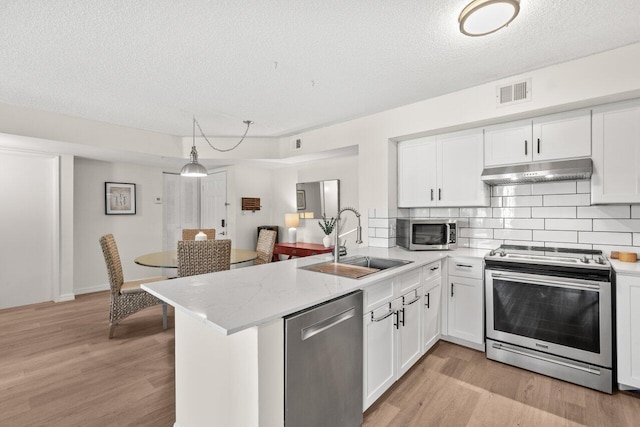 127 Yacht Club Way Unit 206, Hypoluxo, FL 33462 - kitchen with under cabinet range hood, visible vents, a sink, a peninsula, and stainless steel appliances