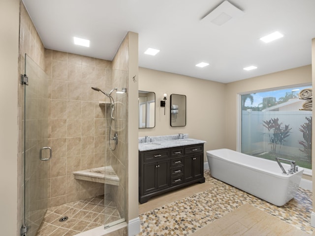 bathroom featuring tile patterned floors, vanity, and shower with separate bathtub