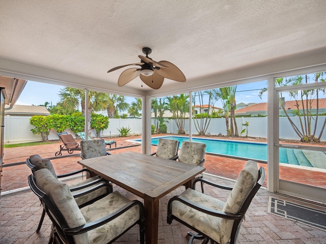 view of patio with ceiling fan and a fenced in pool