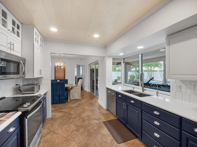 kitchen featuring white cabinets, backsplash, blue cabinets, and stainless steel appliances