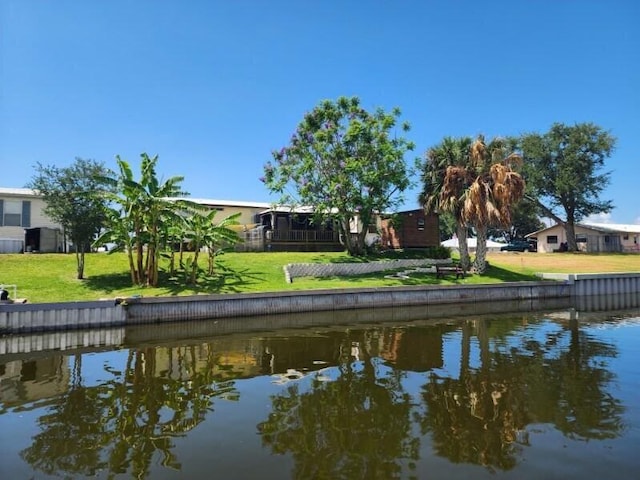 exterior space with a water view and a lawn