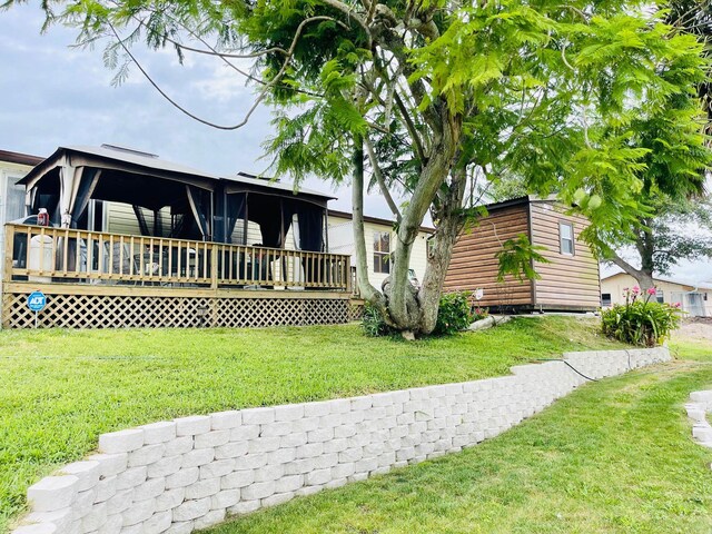 view of front of property with a deck and a front lawn