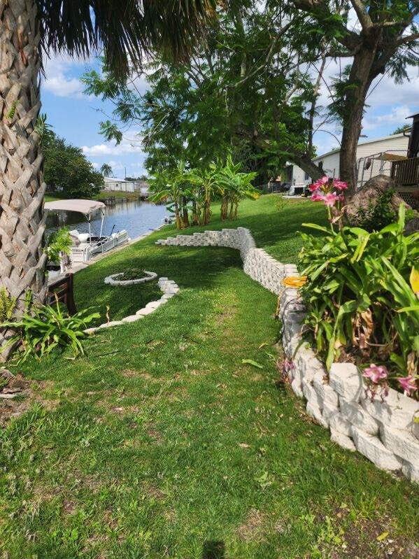 view of yard with a water view and a dock