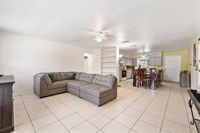 tiled dining room with ceiling fan and sink