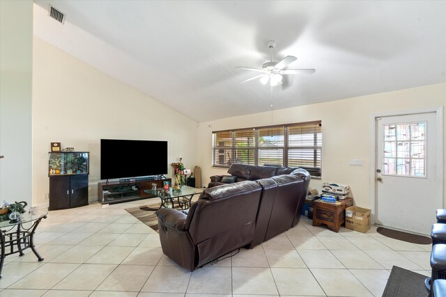 living room with a wealth of natural light, ceiling fan, vaulted ceiling, and light tile flooring