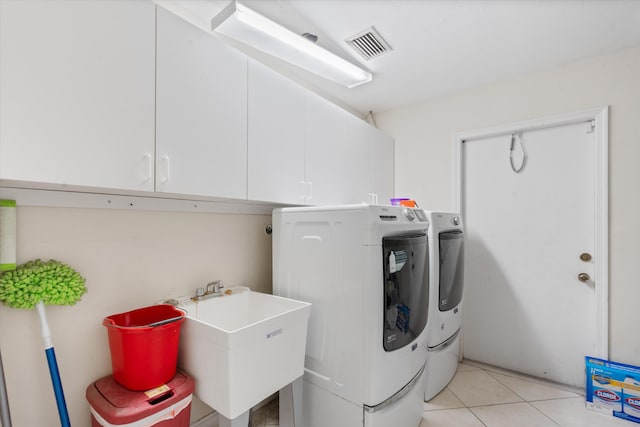 laundry area featuring cabinets, sink, washing machine and dryer, and light tile flooring