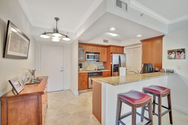 kitchen with tasteful backsplash, pendant lighting, kitchen peninsula, and stainless steel appliances