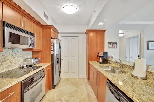 kitchen with light stone counters, a textured ceiling, light tile floors, sink, and appliances with stainless steel finishes