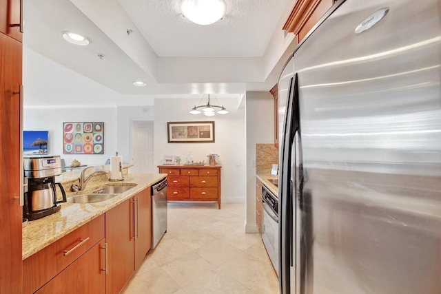 kitchen with a textured ceiling, stainless steel appliances, light stone counters, sink, and light tile floors