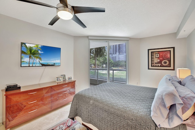 bedroom with ceiling fan, a textured ceiling, carpet flooring, and access to exterior