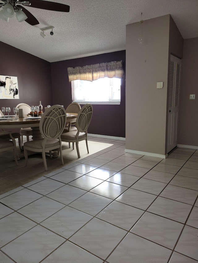 tiled dining space featuring ceiling fan, a textured ceiling, and vaulted ceiling