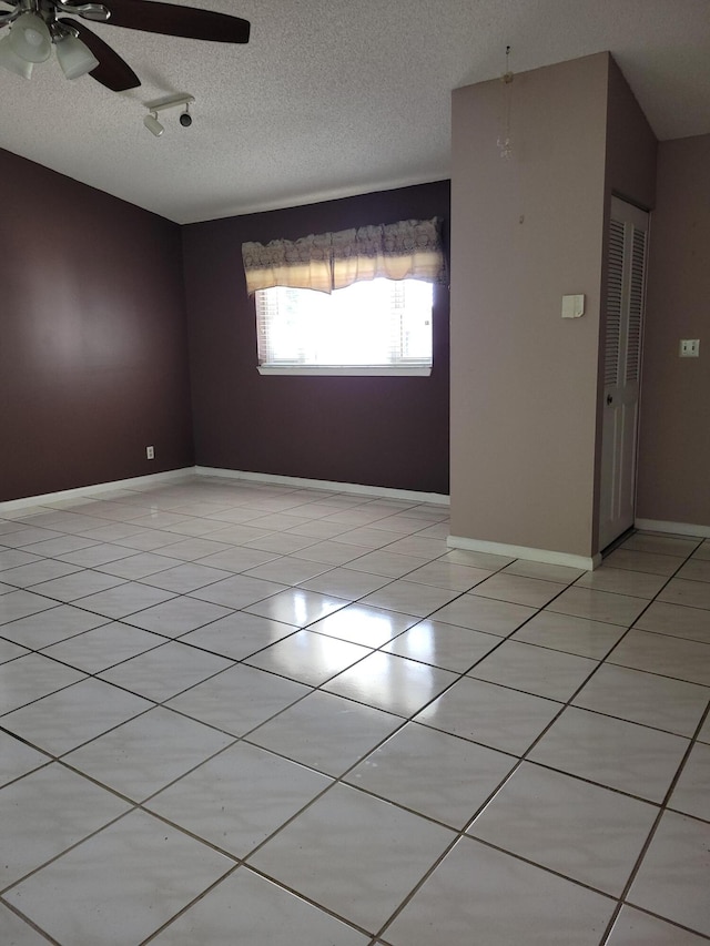 empty room featuring a textured ceiling and light tile patterned flooring