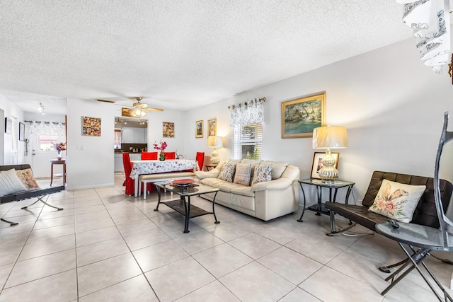 living room with light tile patterned flooring, a textured ceiling, and a wealth of natural light