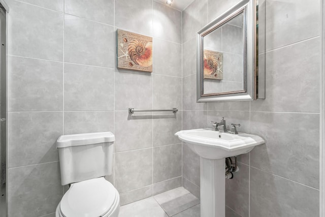 bathroom featuring tile walls and toilet
