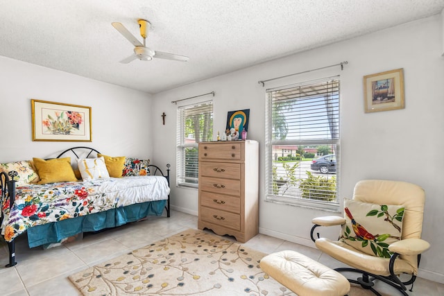 bedroom with baseboards, a textured ceiling, ceiling fan, and light tile patterned floors