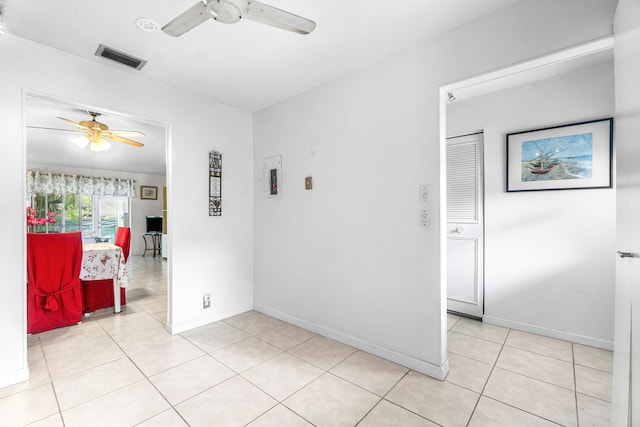 unfurnished room featuring baseboards, ceiling fan, visible vents, and light tile patterned floors