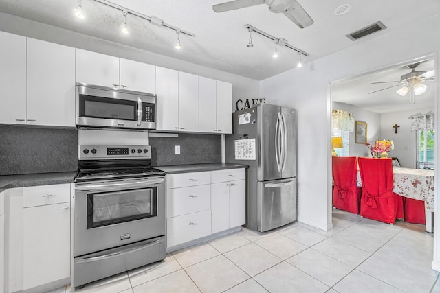 kitchen with ceiling fan, stainless steel appliances, white cabinets, and visible vents
