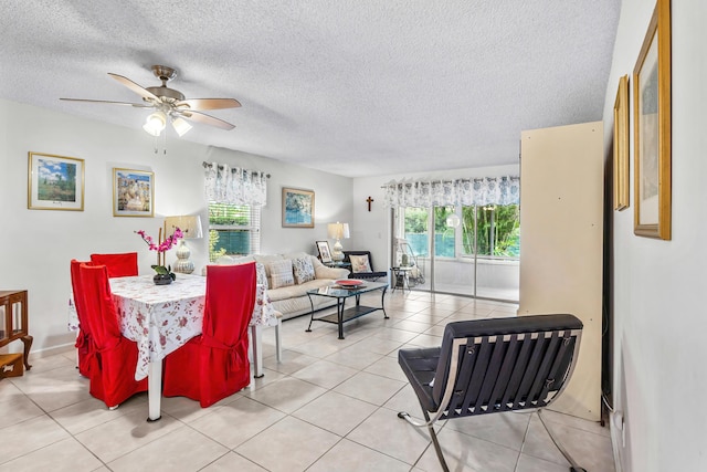 dining area with a textured ceiling, ceiling fan, and light tile patterned floors