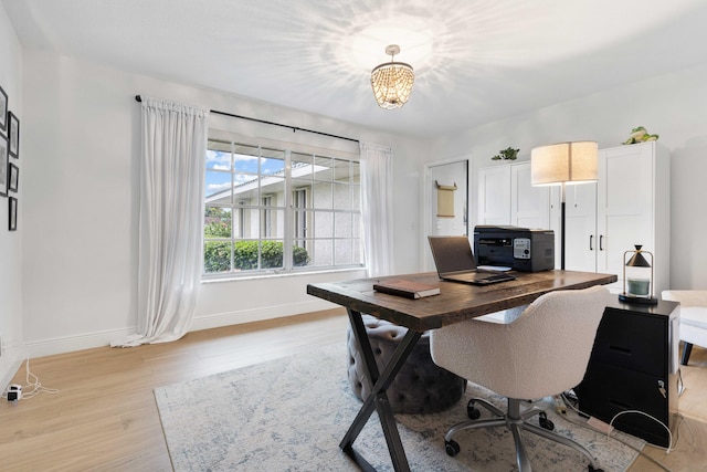 office with an inviting chandelier and light hardwood / wood-style floors