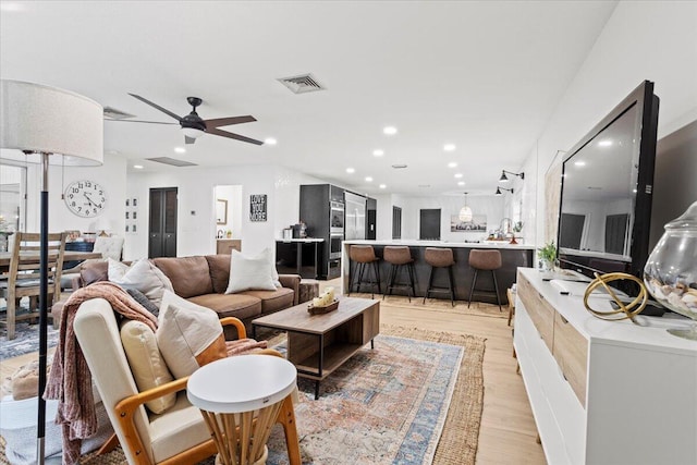 living room featuring ceiling fan and light hardwood / wood-style floors