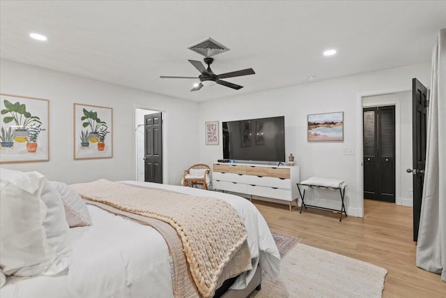 bedroom featuring light wood-type flooring, ceiling fan, and a closet