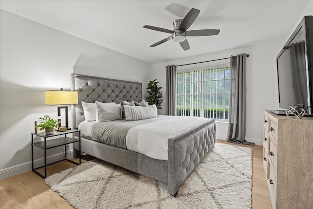 bedroom with ceiling fan and light hardwood / wood-style floors