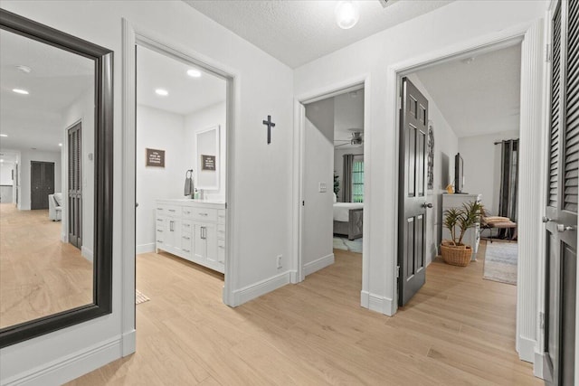 corridor featuring light hardwood / wood-style floors and a textured ceiling