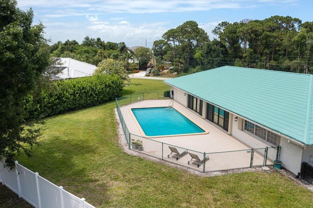 view of pool with a patio area and a yard