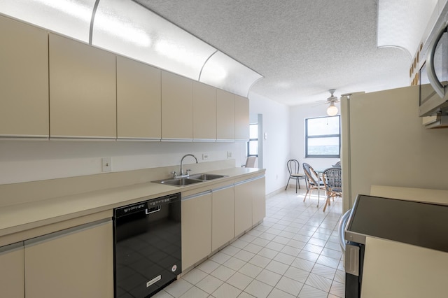 kitchen featuring a textured ceiling, stove, a sink, dishwasher, and stainless steel microwave