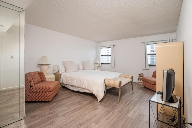 bedroom with light wood finished floors and a textured ceiling