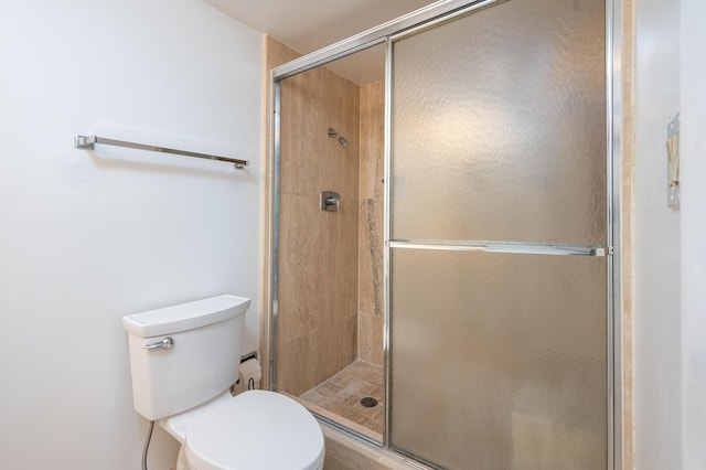 bathroom featuring a stall shower and toilet