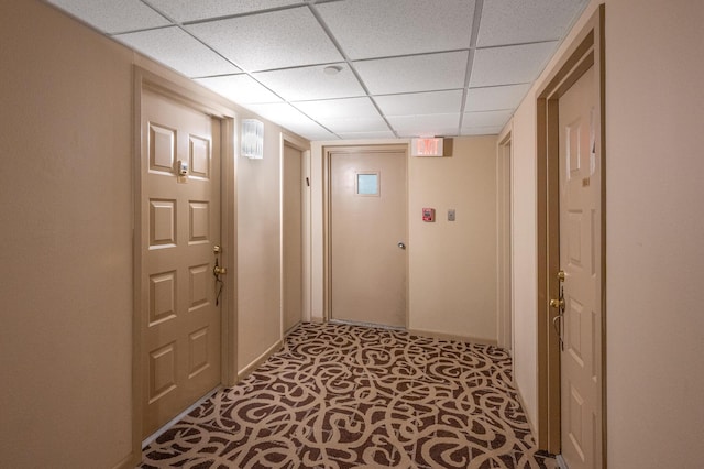 hallway with a paneled ceiling