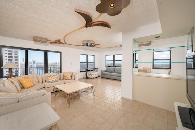 living area featuring a view of city, a ceiling fan, and a textured ceiling