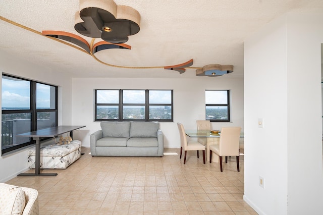 living room featuring a textured ceiling, plenty of natural light, and baseboards