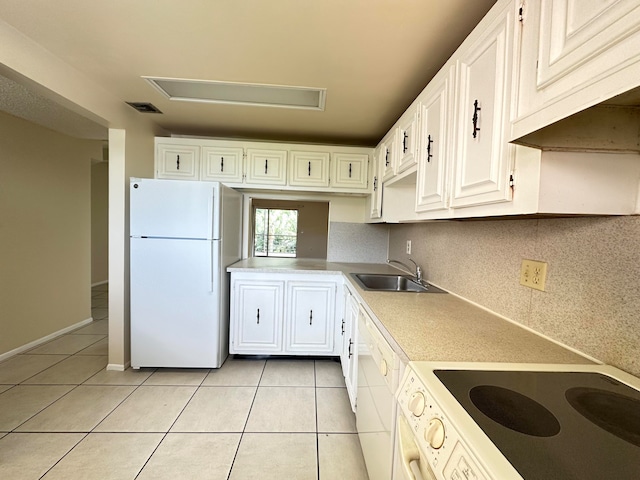 kitchen featuring tasteful backsplash, white appliances, light tile floors, sink, and white cabinetry