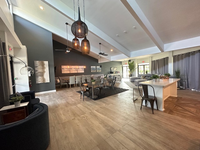 living room featuring beamed ceiling, ceiling fan, and high vaulted ceiling