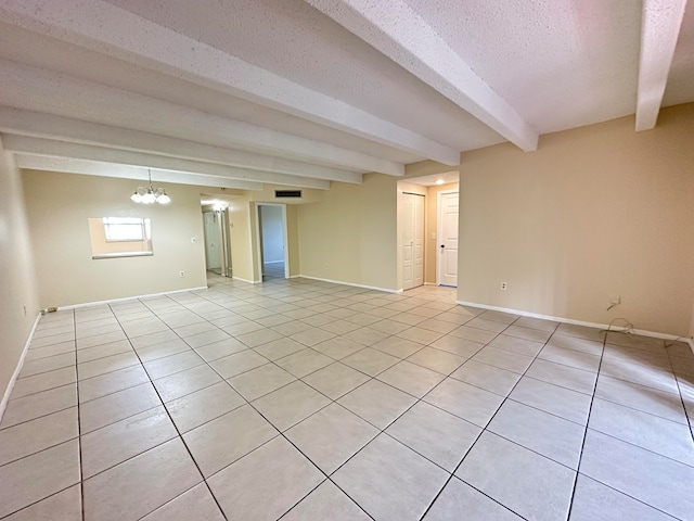 tiled empty room with a chandelier, beam ceiling, and a textured ceiling