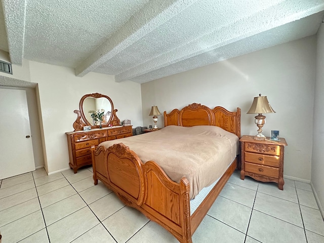 tiled bedroom featuring beam ceiling and a textured ceiling