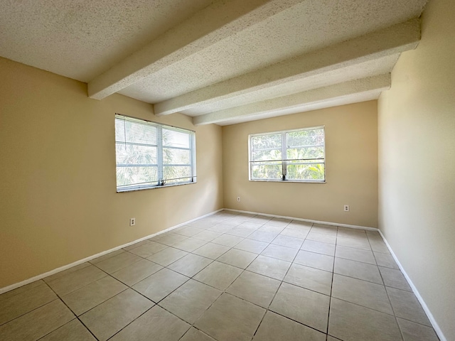 unfurnished room featuring beam ceiling, a textured ceiling, and light tile flooring