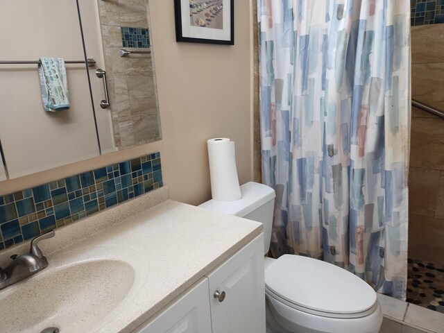 bathroom with curtained shower, vanity, toilet, and backsplash