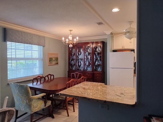 tiled dining area featuring ceiling fan with notable chandelier and ornamental molding