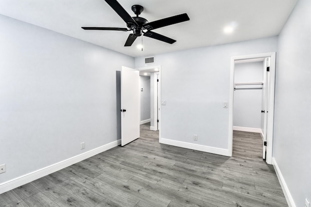 unfurnished bedroom with ceiling fan, a closet, and light hardwood / wood-style floors