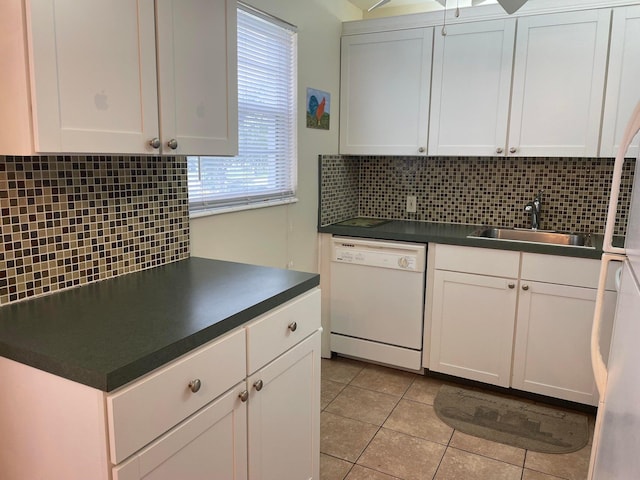 kitchen with white dishwasher, white cabinets, sink, and backsplash