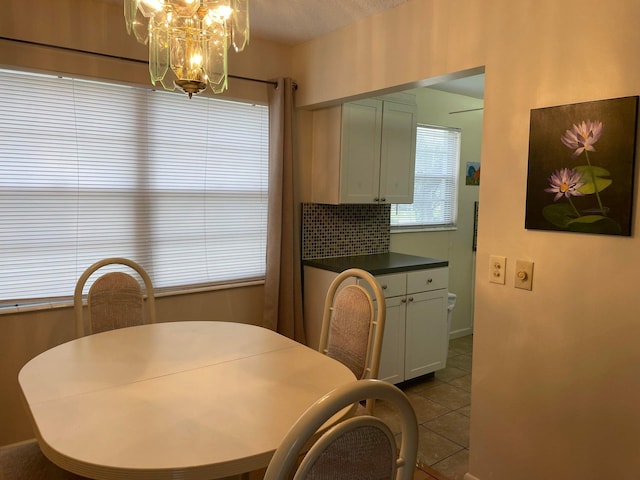 tiled dining room with a notable chandelier