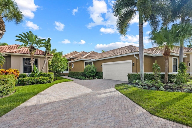 mediterranean / spanish home with a garage and a front lawn