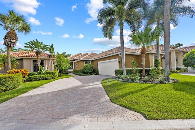 mediterranean / spanish home featuring a garage and a front lawn